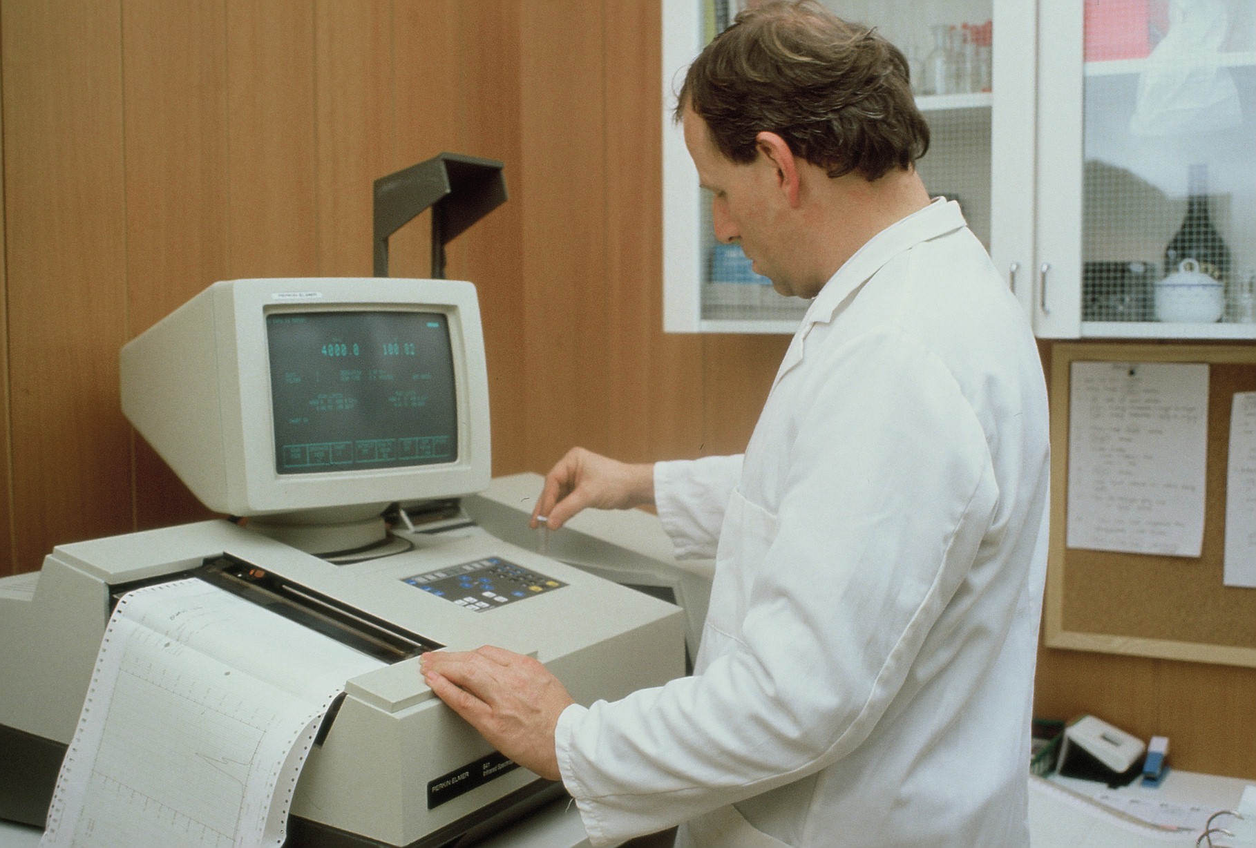 Historisches Foto von Dr. Johann Rietzler (1986) bei der Arbeit an einem der ersten Laborgeräte - einem Spektralphotometer - des 1-Mann-Unternehmens „Dr. Rietzler – Labor für Umweltanalytik“